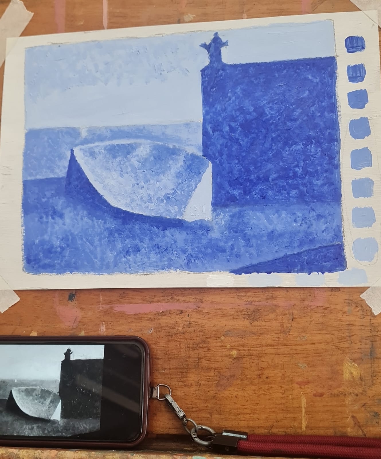 Aluna pintando a óleo uma paisagem litorânea com rocha avermelhada e mar no atelier de Gabriel Paz em Botafogo.