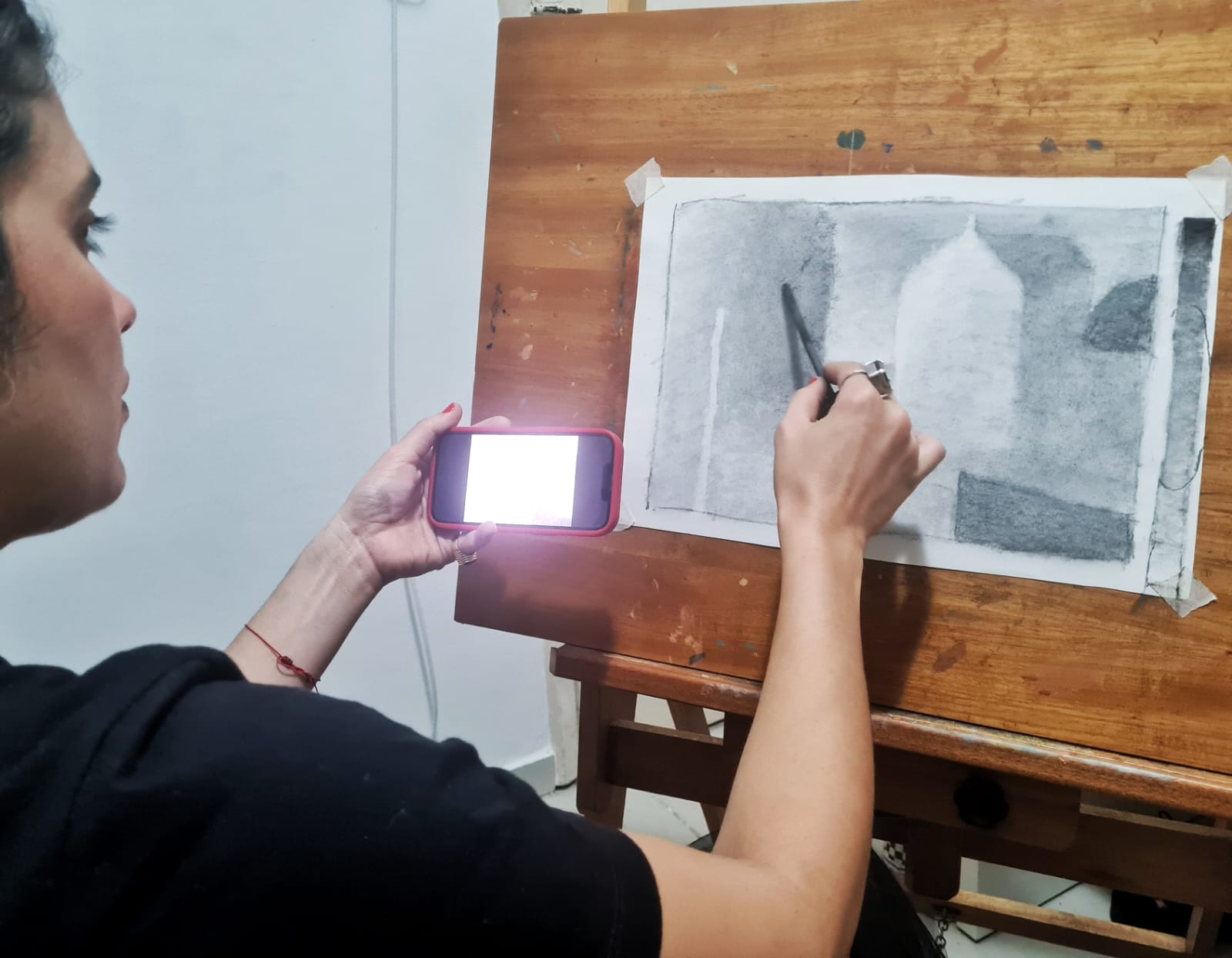 Estudo a carvão de formas arquitetônicas com domo, em tons cinza e preto sobre papel branco, trabalho de aluno do atelier.
